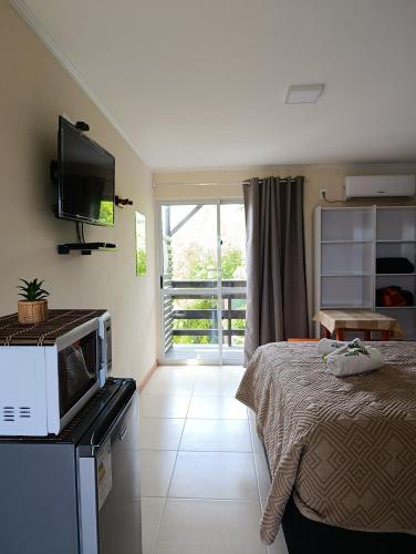 a bedroom with a bed and a microwave on a counter at Aparts Dunas de Valizas in Barra de Valizas