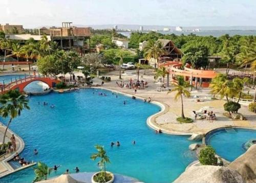 ein großer Pool in einem Resort mit Menschen darin in der Unterkunft Alquilo apto 8 personas en Caribbean Suit - Tucacas in Los Corales