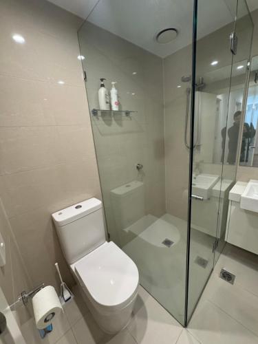 ein weißes Badezimmer mit Toilette und Dusche in der Unterkunft Beautiful light filled modern apartment in Kew in Melbourne
