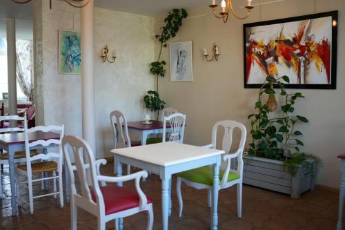 mesa y sillas en un restaurante con mesa y sillas en Hôtel Picardia, en Saint-Valery-sur-Somme