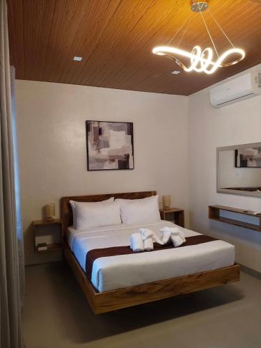 a bedroom with a bed with two stuffed animals on it at Emman's Guest House in Anda