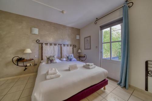 ein Schlafzimmer mit großem Bett und Fenster in der Unterkunft Hotel Restaurant Le Gardon - Pont du Gard in Collias