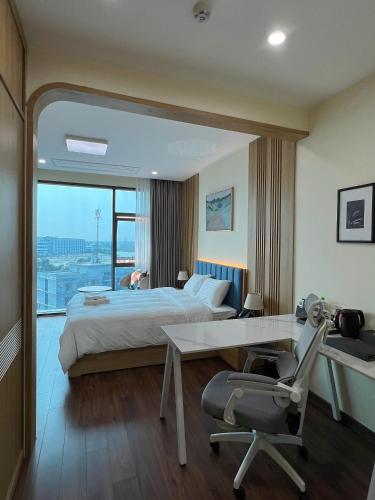 a hotel room with a bed and a desk and a window at Uberzen Residence Hotel in An Dương