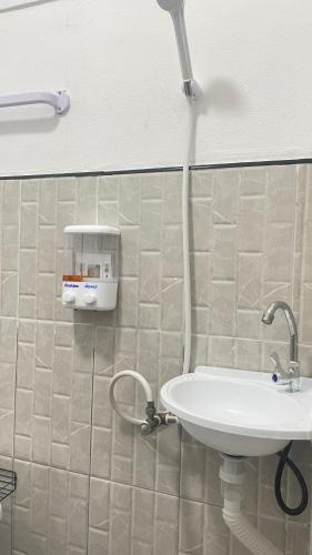 a bathroom with a white sink and a shower at Baanlek Guest House in Ko Lanta