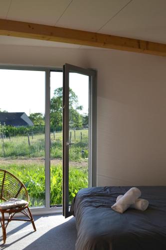a bedroom with a bed and a large window at Grange habitée, nature & design in Manou