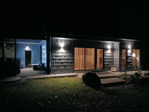 ein kleines Haus in der Nacht mit Beleuchtung in der Unterkunft Arakaoja saunamaja in Nepste