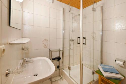 une salle de bain blanche avec une douche et un lavabo dans l'établissement Rundblick 4 Panorama Groß, à Tschagguns