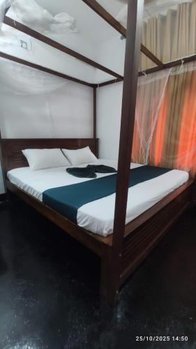 a bedroom with a bunk bed with white sheets at EVOKE Hostel Mirissa in Mirissa
