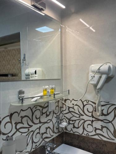 a bathroom with a sink and a mirror at The Artist Regency Hotel Tashkent in Toshkent-Passajir Bekati
