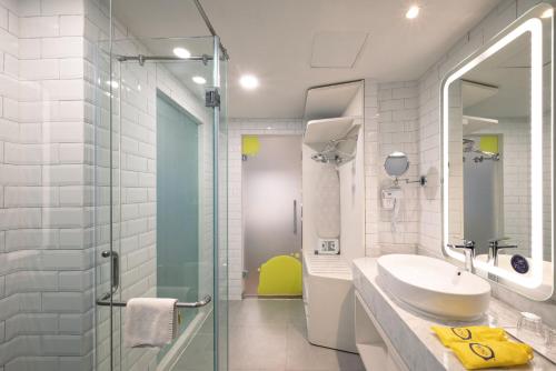 ein Badezimmer mit Waschbecken und Glasdusche in der Unterkunft Yello Hotel Jambi in Jambi