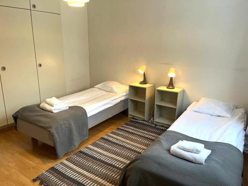 - 2 lits dans une chambre avec 2 lampes et un tapis dans l'établissement Kotimaailma - Tilava kaksio Kotkan Rauhalassa, à Kotka