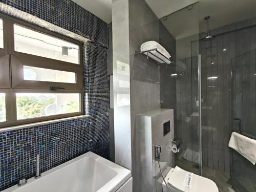 a bathroom with a tub and a sink and a window at Treat Imperial in Aurangabad