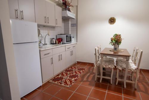 une cuisine avec une table et un réfrigérateur blanc dans l'établissement Snow Chalets Parnassos Arachova's Nest, à Arachova