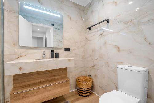 a bathroom with a toilet and a sink and a mirror at Piso Maria in San Miguel de Salinas