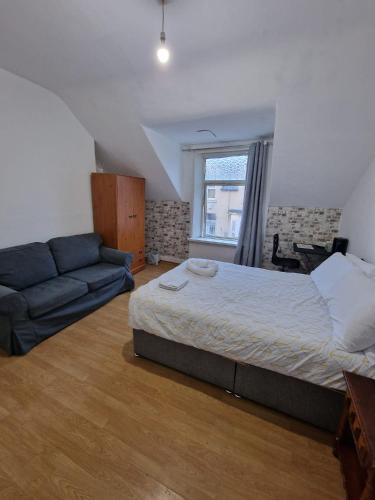 a bedroom with a bed and a couch at Princess Homestay in Sunderland