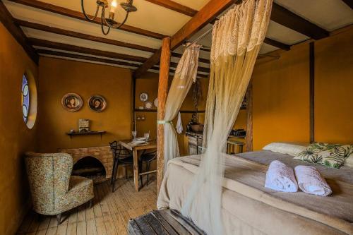 a bedroom with a bed and a desk and a chair at Casa dos Hobbits: Lago, cascata, caiaque, piscina in Itatiba