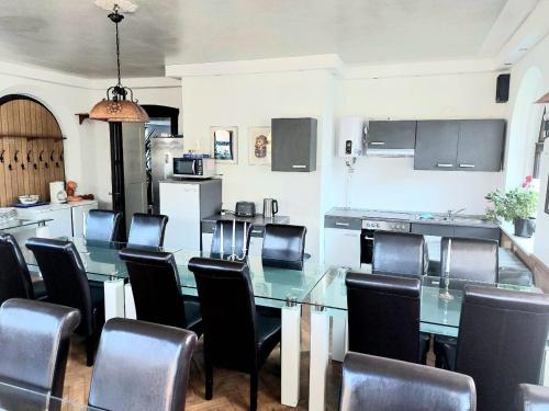 une salle à manger avec une table en verre et des chaises noires dans l'établissement Top Unterkunft für Monteure, à Auf der Wiese
