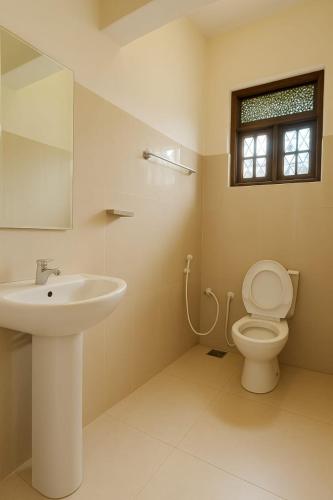 a bathroom with a sink and a toilet and a window at Comfy Stay in Badulla