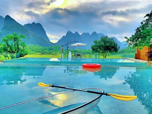 a kayak on the water with mountains in the background at Paddy Fields Resort-Guilin Shuidaotian in Yangshuo