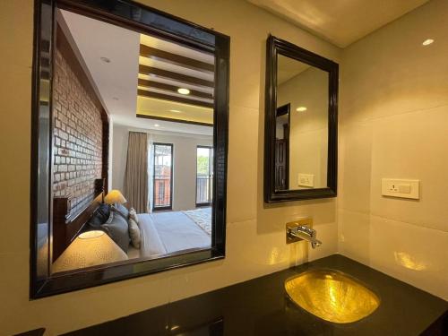 a bathroom with a sink and a large mirror at Ambassador Garden Home in Kathmandu
