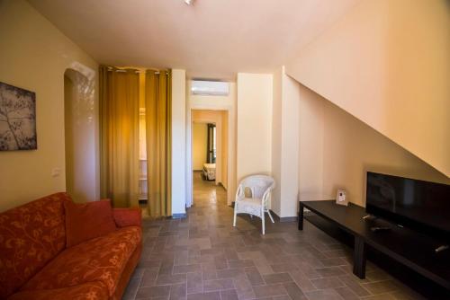 ein Wohnzimmer mit Sofa und Fernseher in der Unterkunft Ferienwohnung Stella in Alberese