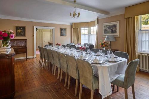 a long dining room with a long table and chairs at Abbey House by Group Retreats in Saffron Walden
