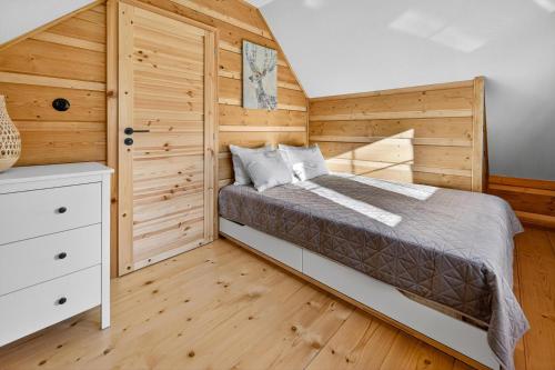 a bedroom with a bed and a wooden wall at Chalet na vrchoch in Nesluša