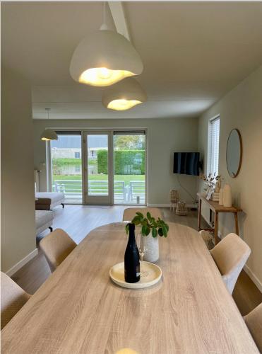 a living room with a wooden table with a bottle on it at Fero Breskens - Modern & kindvriendelijk vakantiehuis op wandelafstand van het strand in Breskens
