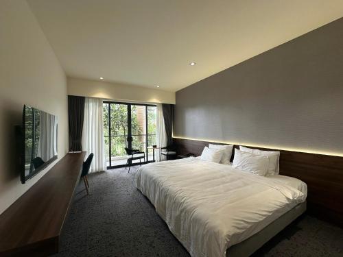 um quarto com uma grande cama branca e uma janela em Mountain Hill em Mai Sơn