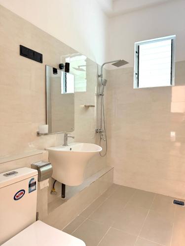 a white bathroom with a sink and a mirror at Pearl Kingdom Hotel & Resort in Matara