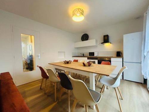a kitchen and dining room with a wooden table and chairs at Casa Les Ponts de Cé in Les Ponts-de-Cé