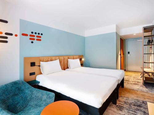 une chambre avec un grand lit et une chaise dans l'établissement ibis Styles Kraków Centrum, à Cracovie