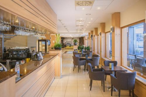 Un restaurante con barra, mesas y sillas. en Hotel Bratislava, en Bratislava