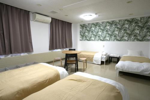 a hospital room with two beds and a table at HOTEL Reise Basis in Senboku