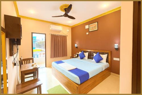 une chambre avec un lit et un ventilateur de plafond dans l'établissement Sayan Lane Road Manshree Palace Resort- Fully Air Conditioning Room# Prime Location# Fully Air Conditioning Room# Prime Location# Parking And Free Wifi- Premium Best Hotel In puri, à Purî