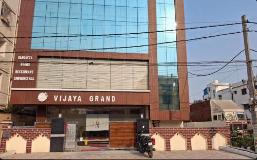 Lok Nayak Jayaprakash AirportにあるHotel vijaya grand, patnaの建物の前に駐車されたバイク