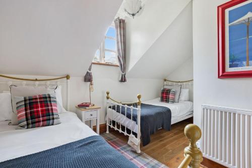 twee bedden in een kamer met witte muren bij Beryas Cottage in Newlyn