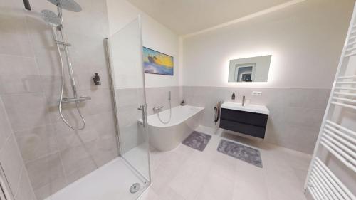 ein weißes Badezimmer mit Dusche und Waschbecken in der Unterkunft Arche Noah Unterkunft in Westoverledingen