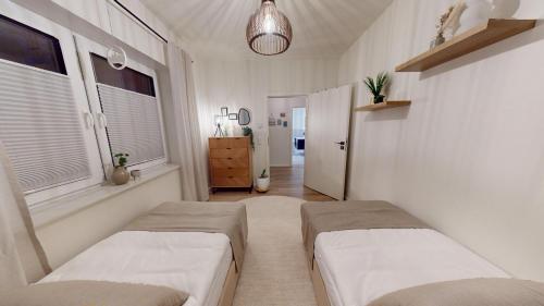 zwei Betten in einem Zimmer mit zwei Fenstern in der Unterkunft Arche Noah Unterkunft in Westoverledingen