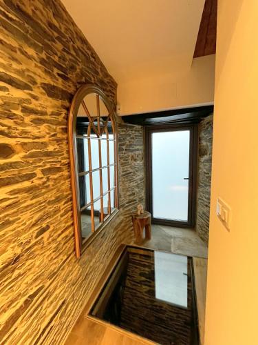 a bathroom with a stone wall and a window at Hotel Apartamentos Casas da Fortaleza in Lugo