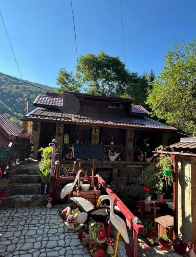 Un edificio con una mesa y sillas delante. en Vila Movila Revelion 2026, en Azuga