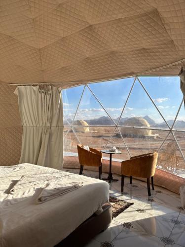 a bedroom with a bed and a view of the desert at RUM HORIZON BUBBlE LUXURY CAMP in Wadi Rum