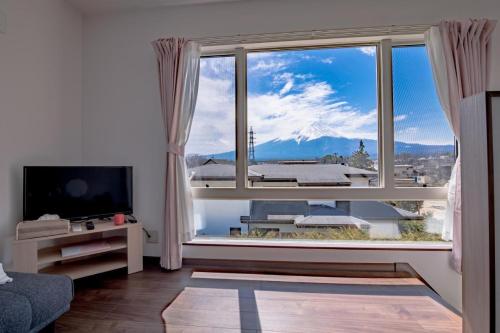 a living room with a large window with a mountain view at SAKURA FUJI in Fujikawaguchiko