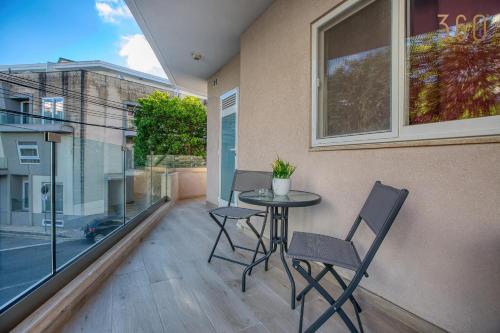 Un patio con una mesa y sillas en un balcón. en Beautiful 3BR homes with comfy beds, WIFI & AC by 360 Estates, en Naxxar
