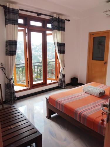 a bedroom with a bed and a large window at Kelum Homestay in Kandy