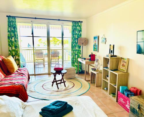 uma sala de estar com um sofá e uma mesa em Grenade Studio les pieds dans l'eau et vue mer Caraïbes dans une magnifique résidence de vacances em Sainte-Luce