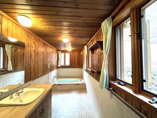 Cabin B vacation house rental Mt Fuji View 3 min lake Saiko 5min drive Lake Kawaguchi في فوجيكاواجوتشيكو: حمام مع مغسلة وحوض استحمام
