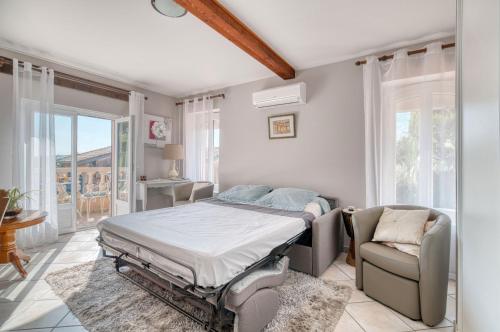 a bedroom with a bed and a couch and a chair at Chez Anne Marie Et Daniel in Gardouch