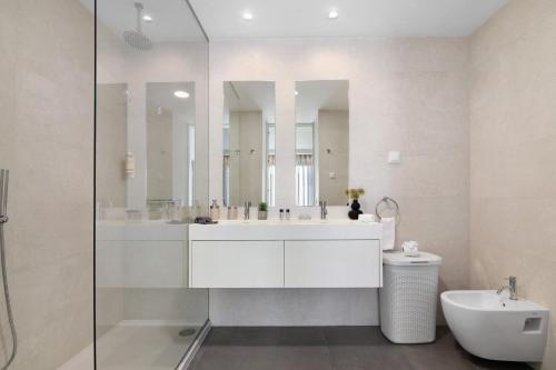 a white bathroom with a sink and a mirror at Casa do Sol and Golf - Vilamoura in Estibeira