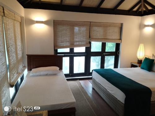 ein Schlafzimmer mit zwei Betten und einem Fenster in der Unterkunft IslandOnBolgoda in Piliyandala